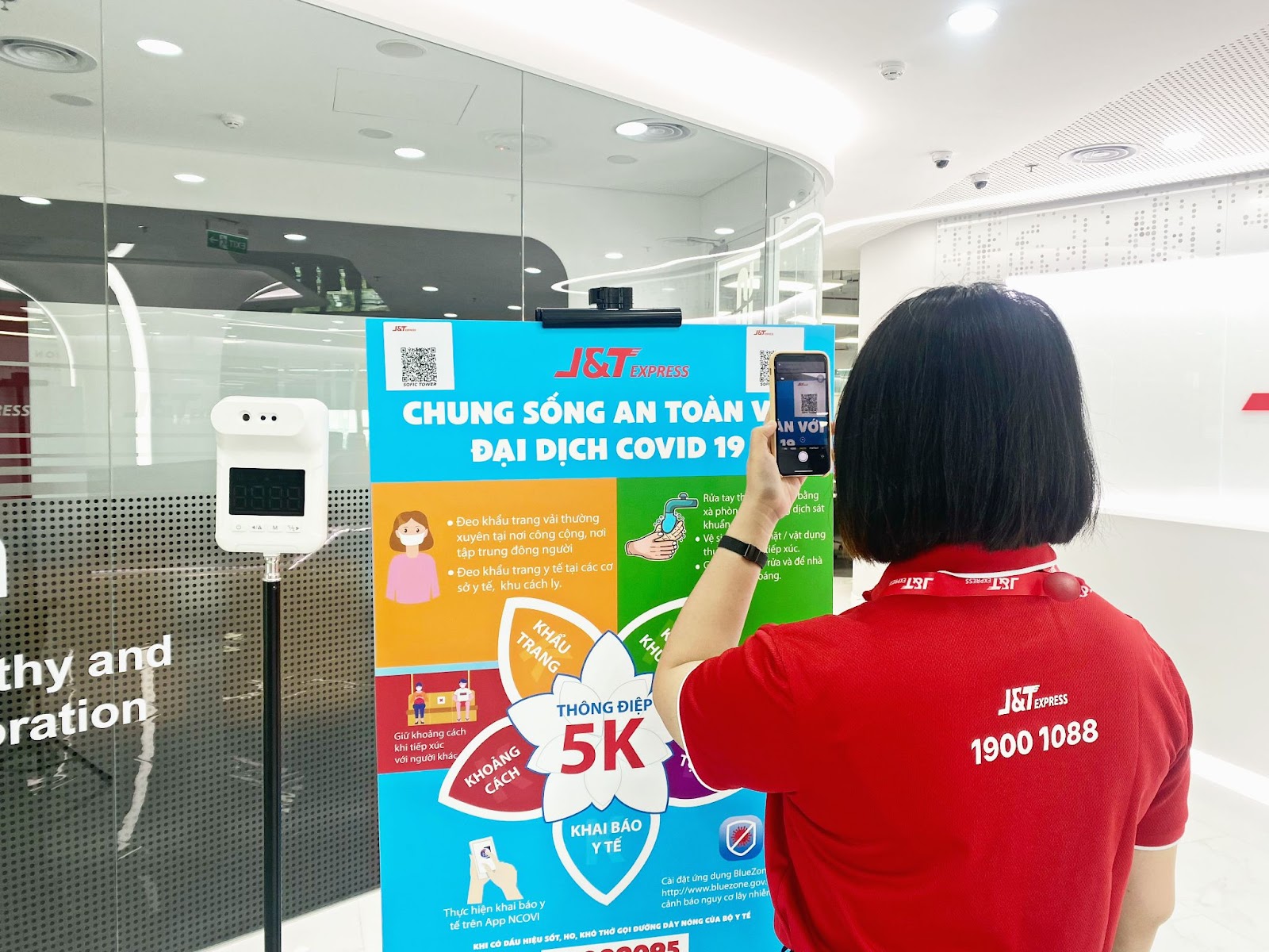 Nhân viên J&T Express khai báo y tế và đo thân nhiệt trước vào văn phòng.