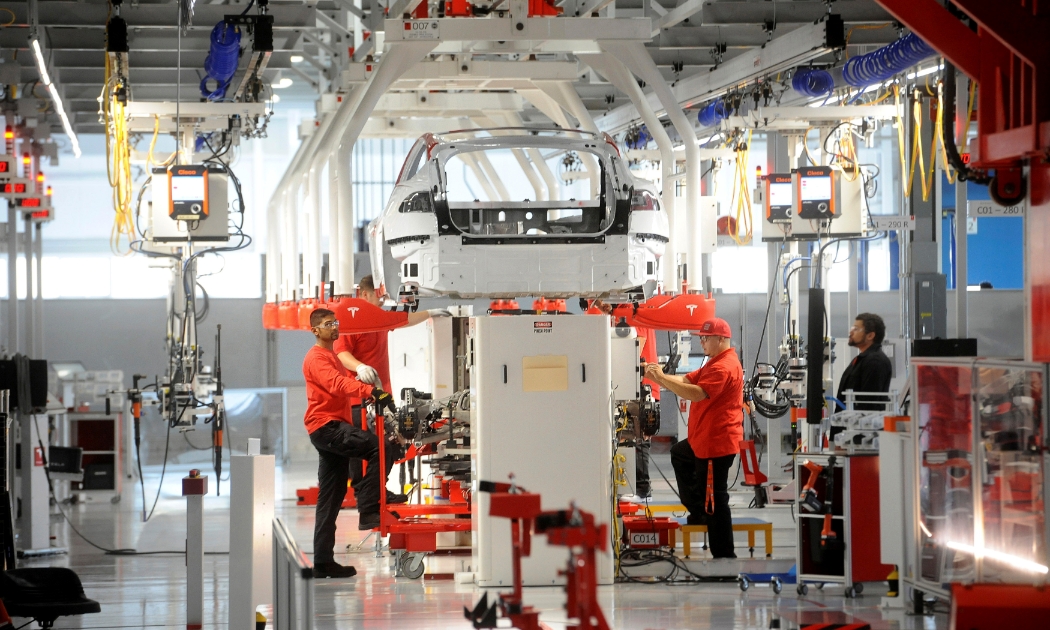 Lắp ráp ô tô điện trong một nhà máy của Tesla ở Mỹ - Ảnh: Reuters.