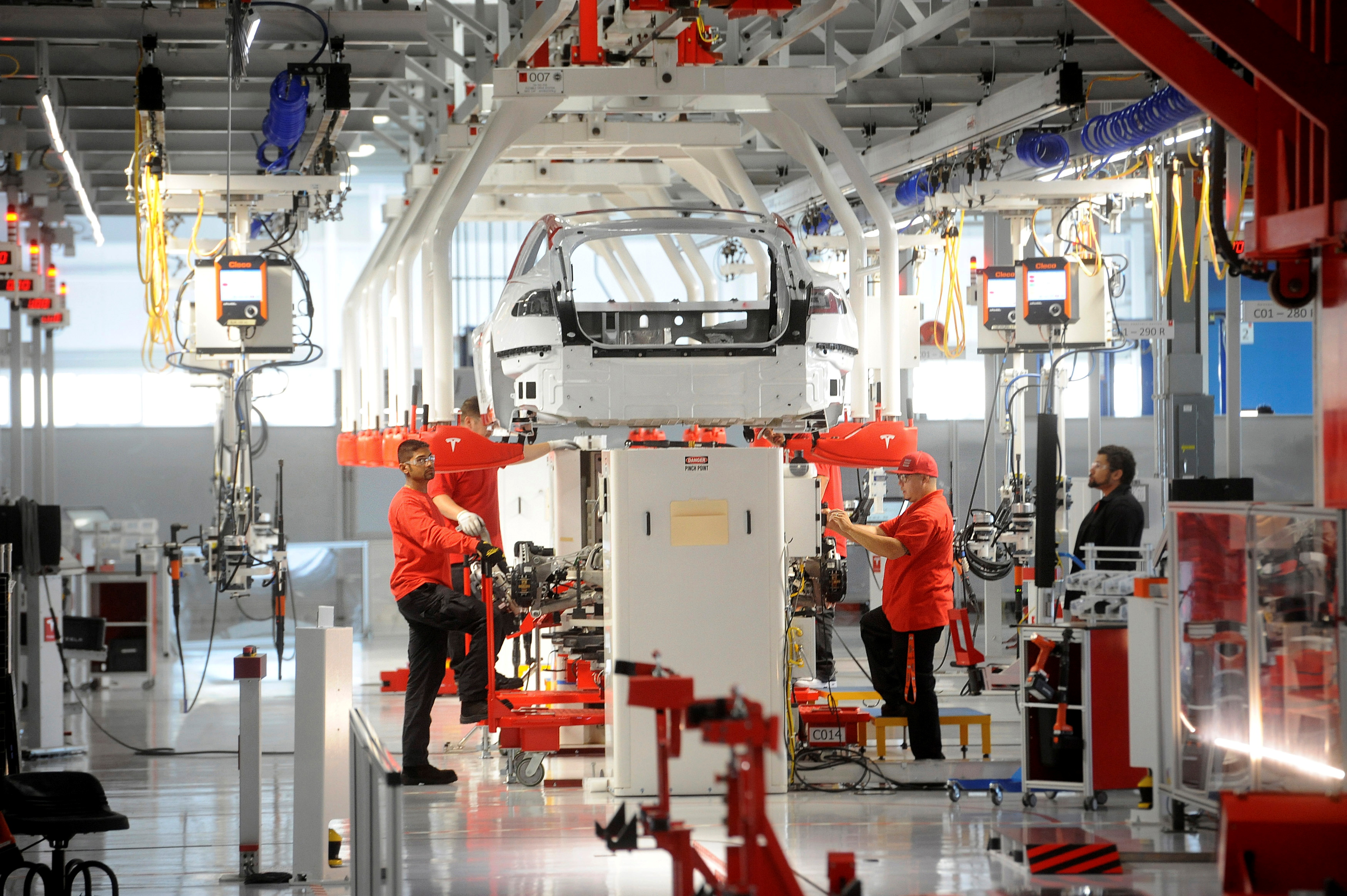 Lắp ráp ô tô điện trong một nhà máy của Tesla ở Mỹ - Ảnh: Reuters.