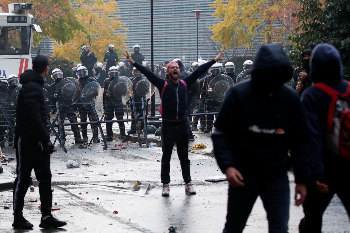 Người biểu tình đối mặt cảnh sát ở Brussels hôm 20/11 - Ảnh: Reuters.