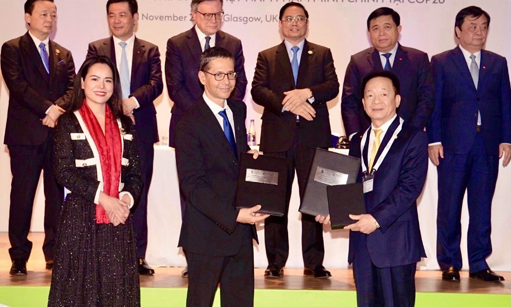 Ông Đỗ Quang Hiển, Chủ tịch Hội đồng Quản trị kiêm Tổng giám đốc Tập đoàn T&T Group (giữa) và ông Patrick Lee, Chủ tịch Standard Chartered Việt Nam, Giám đốc Standard Chartered Singapore và thị trường ASEAN (bên phải) trao biên bản ghi nhớ tài trợ vốn 6 tỷ USD cho các dự án xanh của T&T Group.