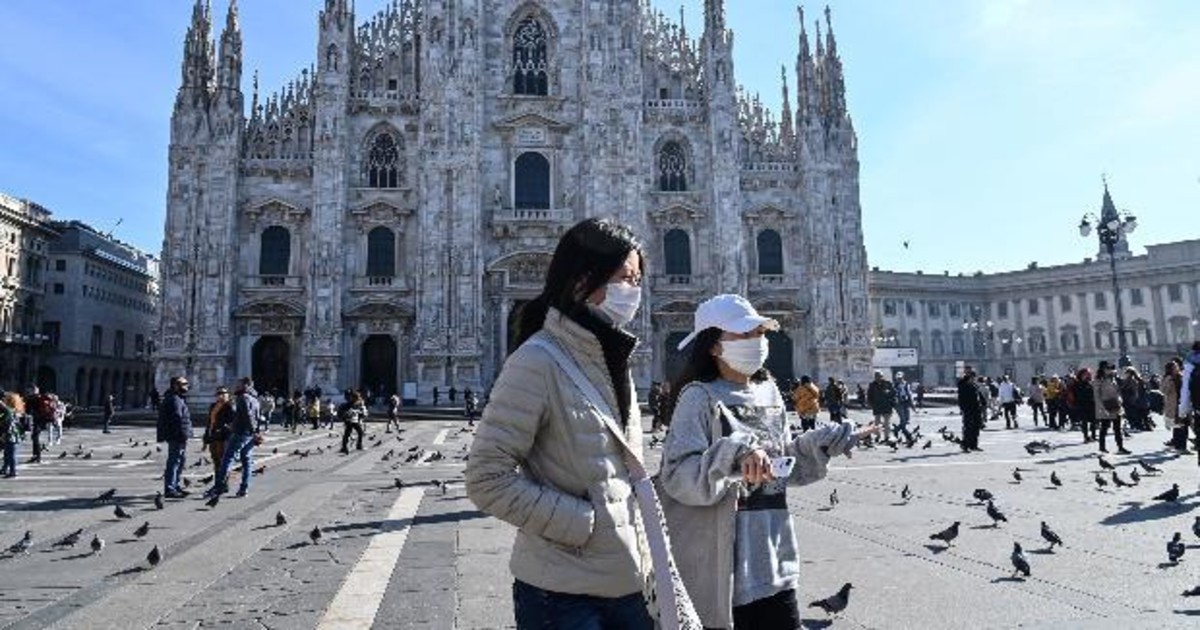 Du khách đi qua một điểm du lịch nổi tiếng tại Milan, Italy giữa đại dịch Covid-19 - Ảnh: AFP