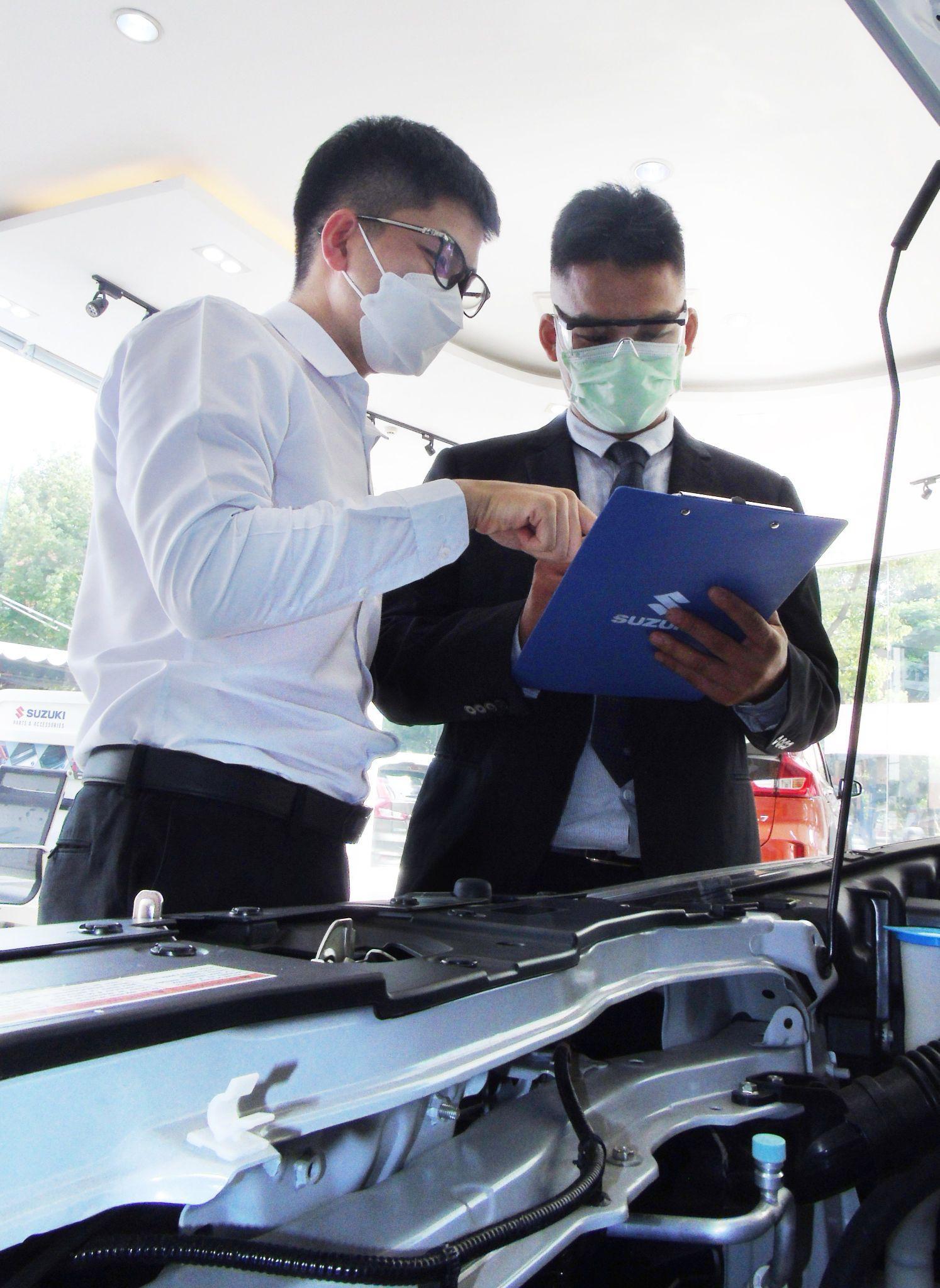 Tại cửa hàng trực tiếp Suzuki World, Ông Nhật Hoàng (bên phải) cũng như các nhân viên khác đều có khả năng hỗ trợ khách bằng nhiều thứ tiếng như tiếng Anh và tiếng Nhật.