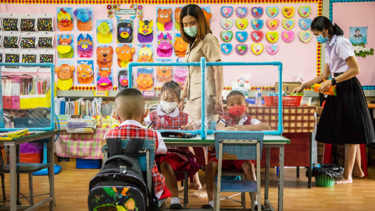 Học sinh mẫu gi&aacute;o tại trường Niyom Songkhrao, Bangkok, Th&aacute;i Lan học c&aacute;ch th&iacute;ch nghi với dịch khi học tập với v&aacute;ch ngăn tr&ecirc;n b&agrave;n khi nước n&agrave;y mở cửa hầu hết trường học - Ảnh: Getty Images