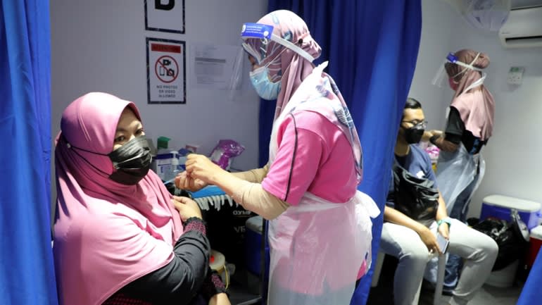 Tiêm vaccine Sinovac trên xe tải lưu động tại Kuala Lumpur, Malaysia - Ảnh: Reuters