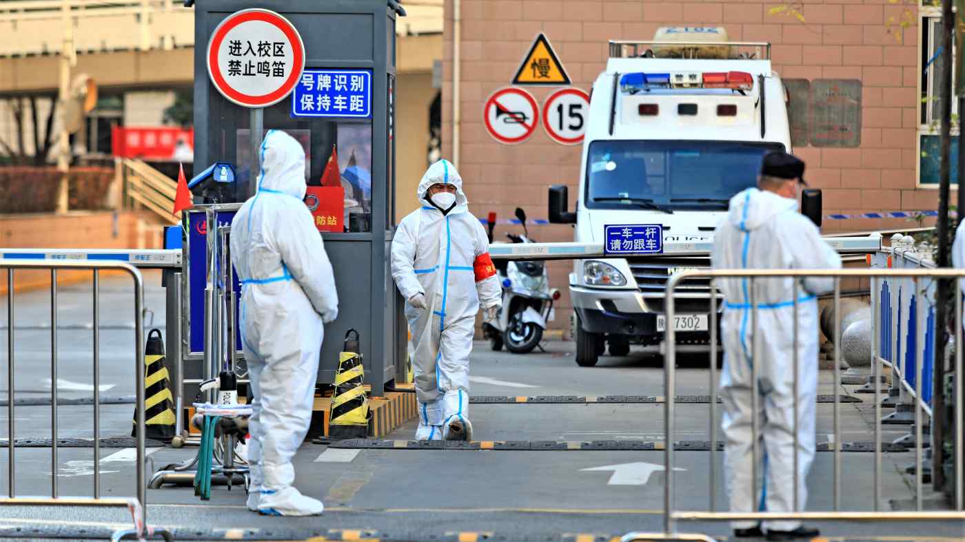 Nh&acirc;n vi&ecirc;n y tế đứng ở lối v&agrave;o một khu d&acirc;n cư bị phong tỏa ở T&acirc;y An, Trung Quốc, v&agrave;o ng&agrave;y 20/12. Ch&iacute;nh phủ duy tr&igrave; phương ph&aacute;p kh&ocirc;ng khoan nhượng để kiểm so&aacute;t Covid-19 - Ảnh: Reuters