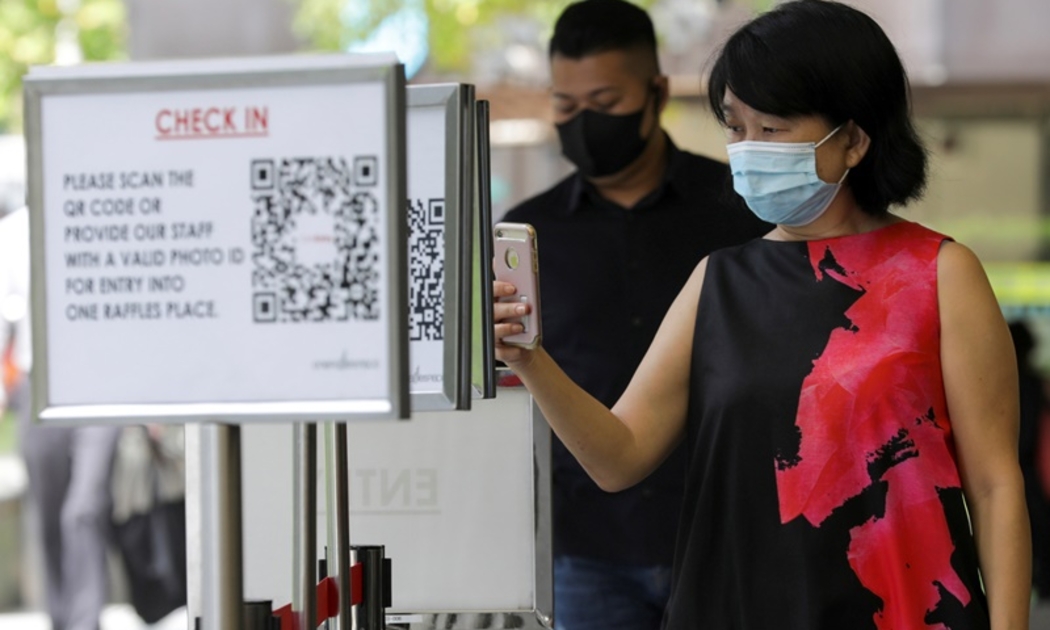 Quét QR code để vào một trung tâm thương mại tại Singapore - Ảnh: Reuters.
