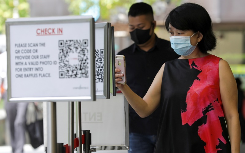 Quét QR code để vào một trung tâm thương mại tại Singapore - Ảnh: Reuters.
