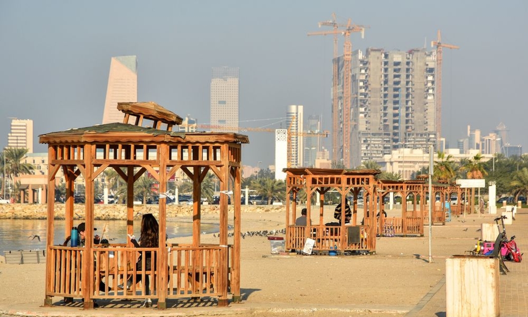 Người dân tránh nắng trên bãi biển Shuwaikh ở thành phố Kuwait, Kuwait - Ảnh: Bloomberg