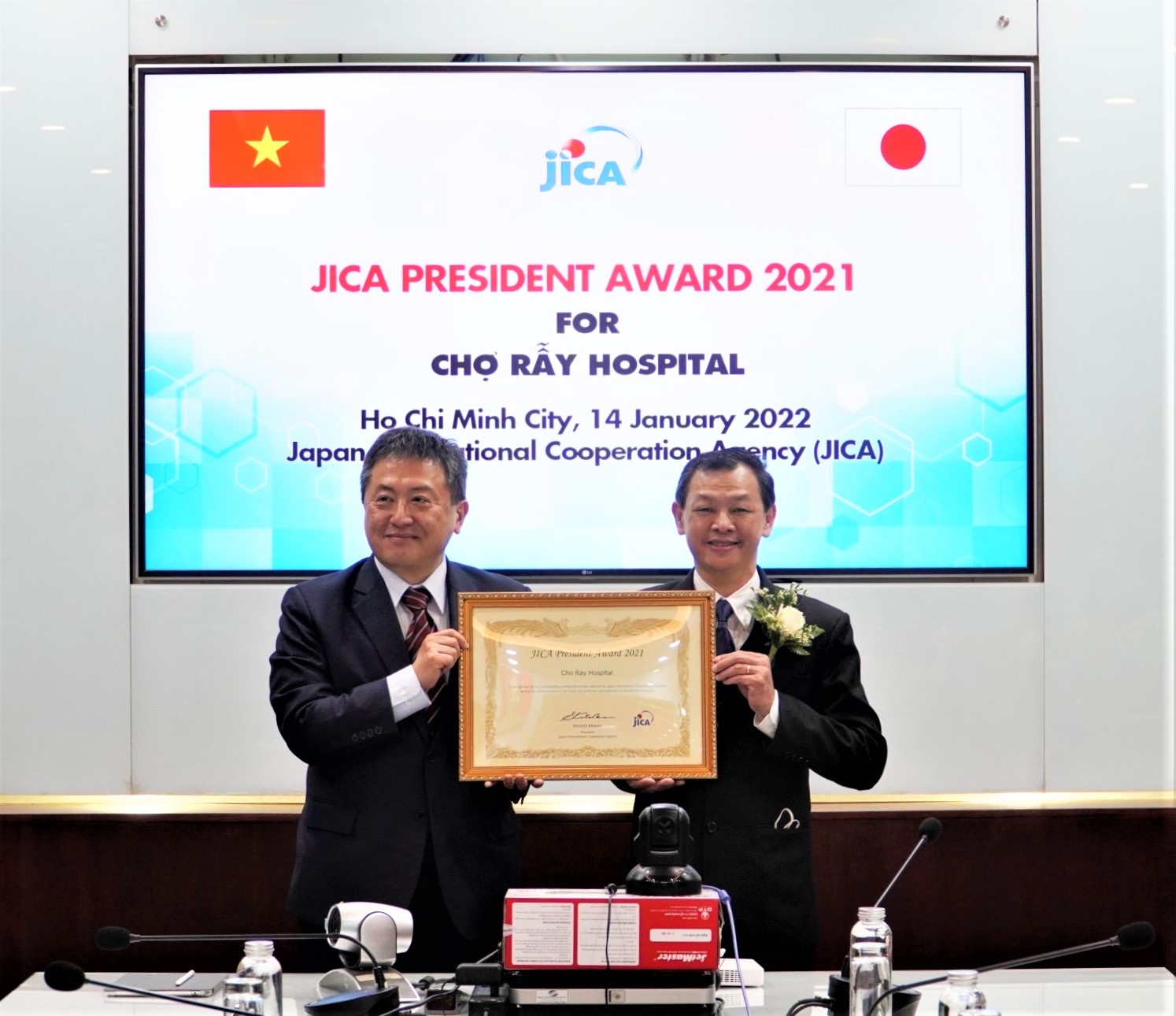 Trưởng Đại diện Văn phòng JICA Việt Nam - ông Shimizu Akira đã trao bằng khen cho TS.BS. Nguyễn Tri Thức - Giám đốc Bệnh viện Chợ Rẫy.