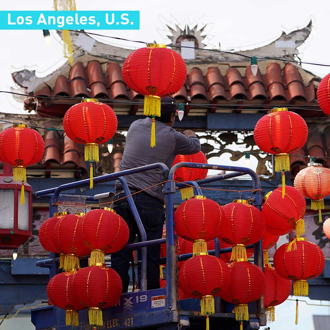 Một người gốc &Aacute; treo đ&egrave;n lồng đ&oacute;n năm mới tại Los Angeles, Mỹ - Ảnh: CGTN