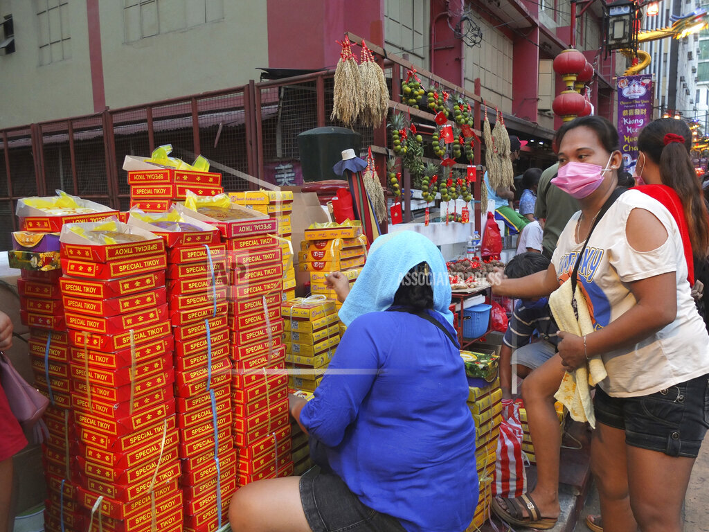 Người bán hàng bán đồ ăn Tết trên phố Ongpin ở Binondo, Manila. Chính quyền thành phố Manila cấm tất cả các hoạt động đón năm mới của người Trung Quốc. Đây là năm thứ hai thành phố này hủy bỏ các hoạt động đón Tết Nguyên đán - Ảnh: AP