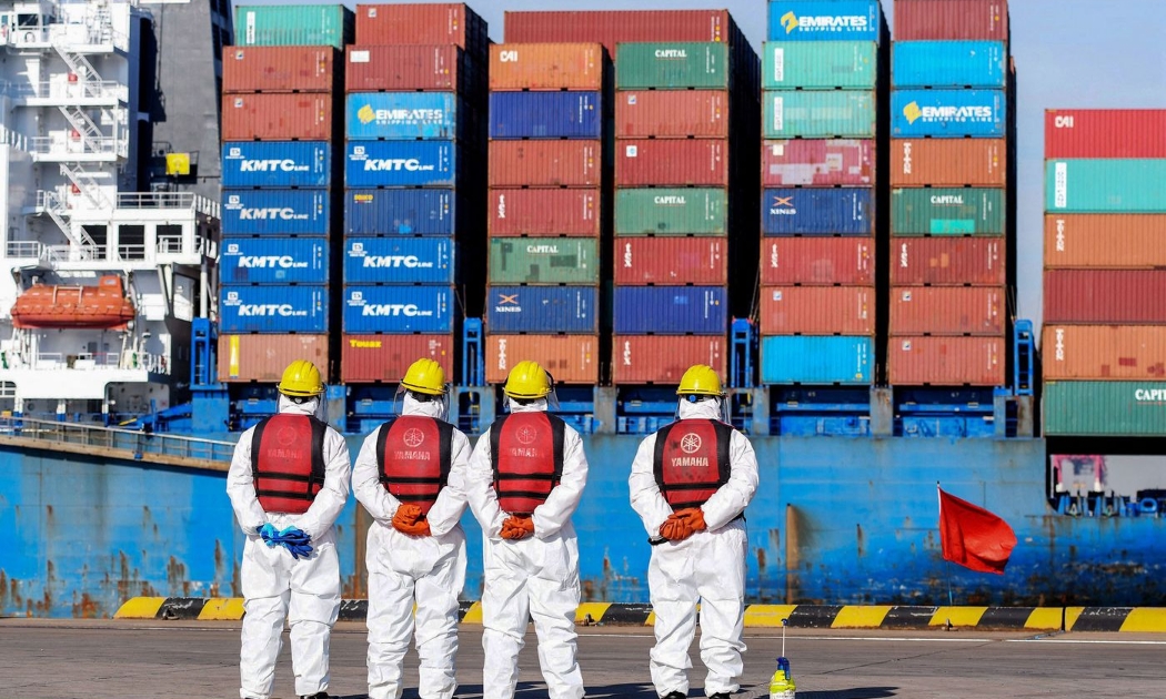 Các công nhân cảng biển trong trang phục bảo hộ ở Thanh Đảo, Trung Quốc hôm 14/1 - Ảnh: Getty/Bloomberg.