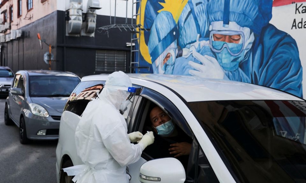Một nhân viên y tế lấy mẫu xét nghiệm tại Shah Alam, Malaysia, ngày 8/2/2022 - Ảnh: Reuters