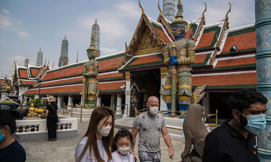 Du khách đeo khẩu trang khi tham quan chùa Phật Ngọc ở Bangkok, Thái Lan - Ảnh: Getty Images