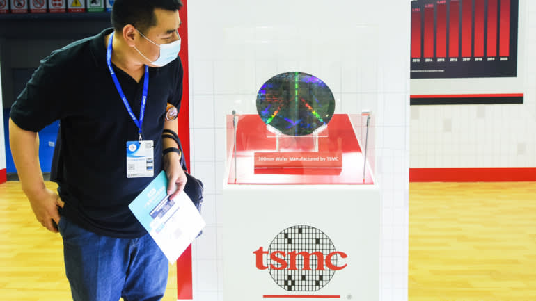Một khách tham quan xem tấm bán dẫn (wafer) 300mm trong gian hàng của TSMC tại một hội chợ thương mại ở Trung Quốc năm 2021 - Ảnh: Getty Images