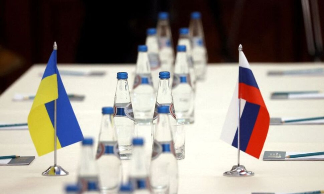 Cờ Ukraine và cờ Nga trên bàn đàm phán giữa quan chức hai nước ở Belarus hôm 28/2 - Ảnh: Reuters.