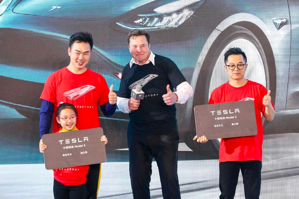 Musk chụp ảnh với các khách hàng mua xe Model 3 tại một sự kiện ở Thượng Hải vào đầu năm 2020 - Ảnh: AFP