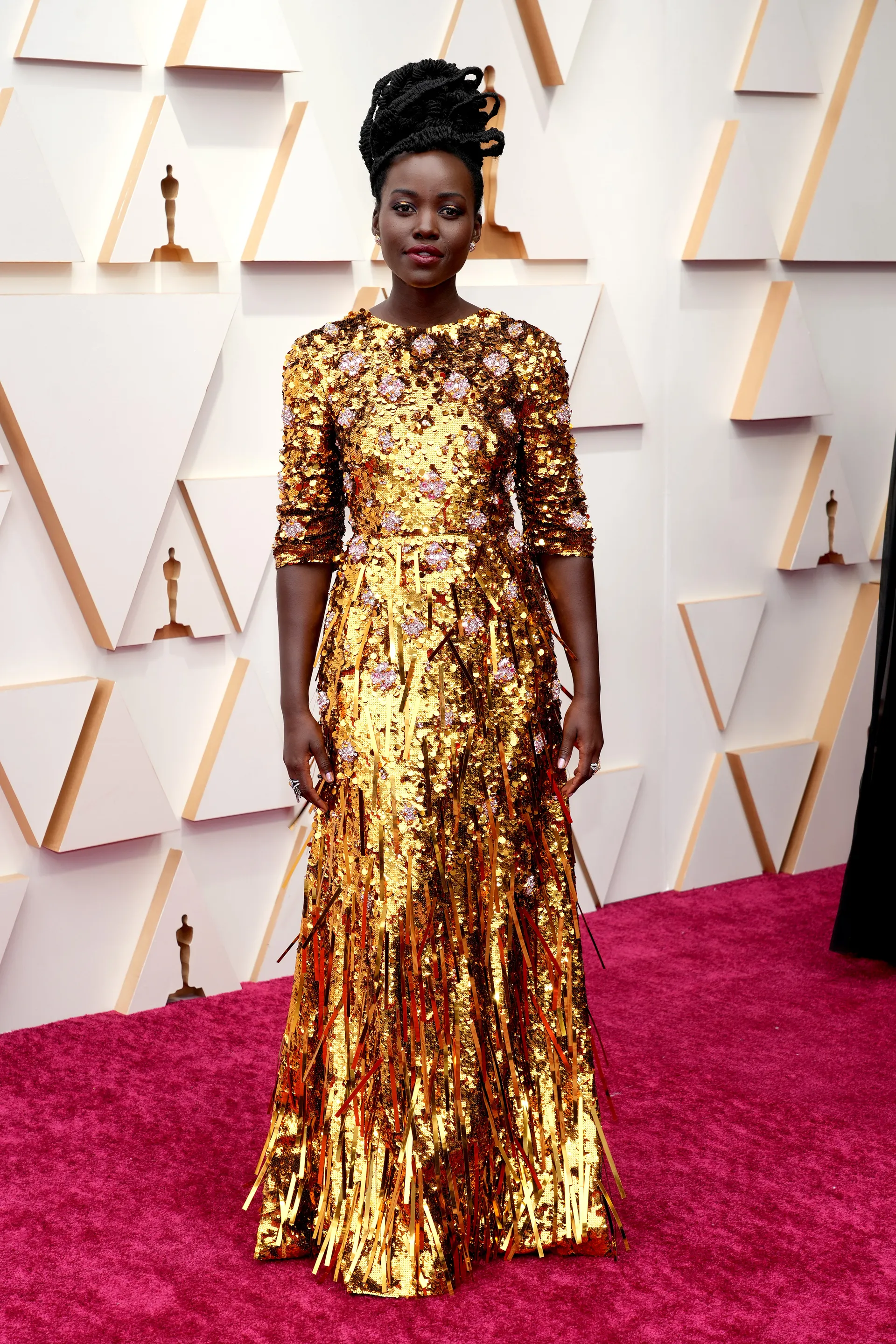 Diễn viên da màu Lupita Nyong'o trong chiếc đầm ánh kim của Prada, với những chi tiết tua rua cầu kỳ.