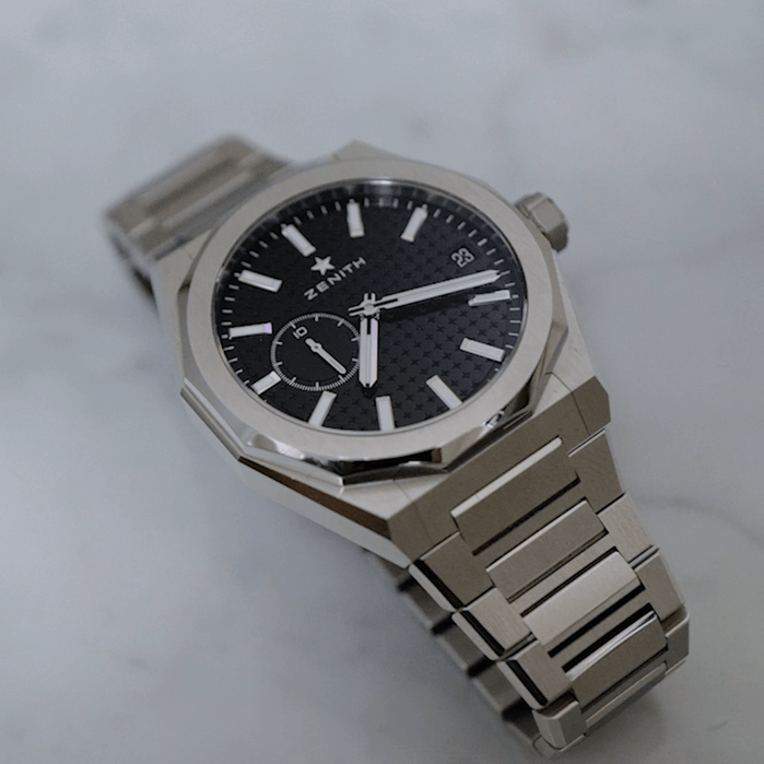 Lịch ng&agrave;y được đặt trong một cửa sổ ở vị tr&iacute; 3 giờ, v&agrave; t&iacute;nh năng gi&acirc;y phụ,&nbsp;hay đ&uacute;ng hơn l&agrave; hiển thị 1/10 gi&acirc;y phụ, được đặt trong một mặt số phụ ở g&oacute;c 9 giờ.