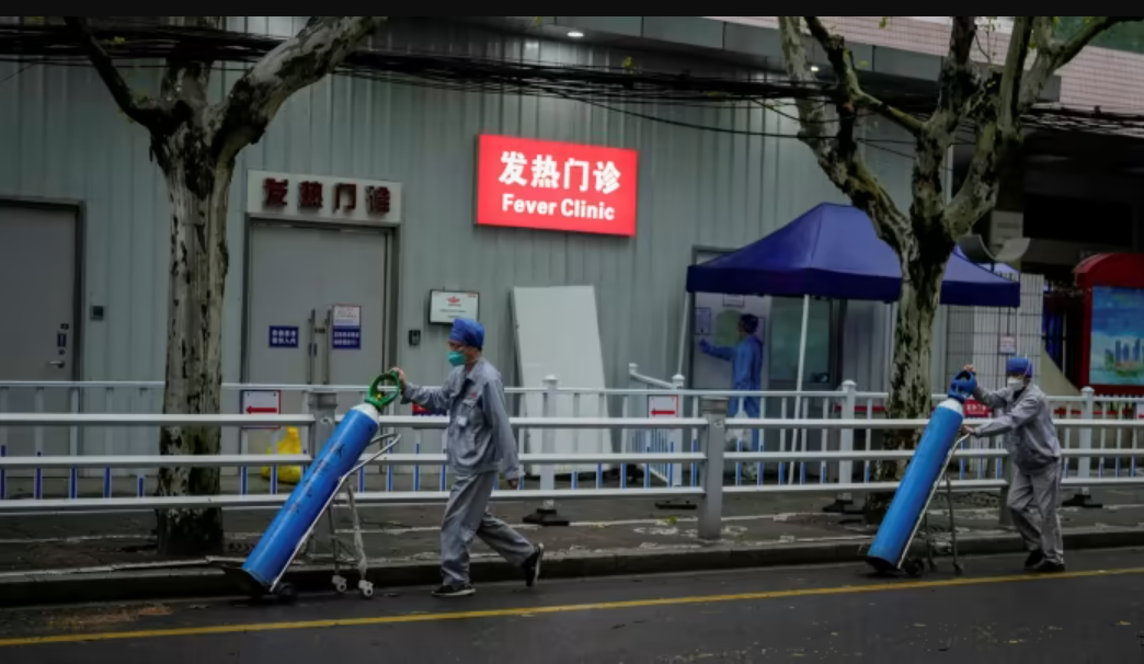 C&ocirc;ng nh&acirc;n vận chuyển b&igrave;nh oxy b&ecirc;n ngo&agrave;i một bệnh viện ở Thượng Hải - Ảnh: Reuters