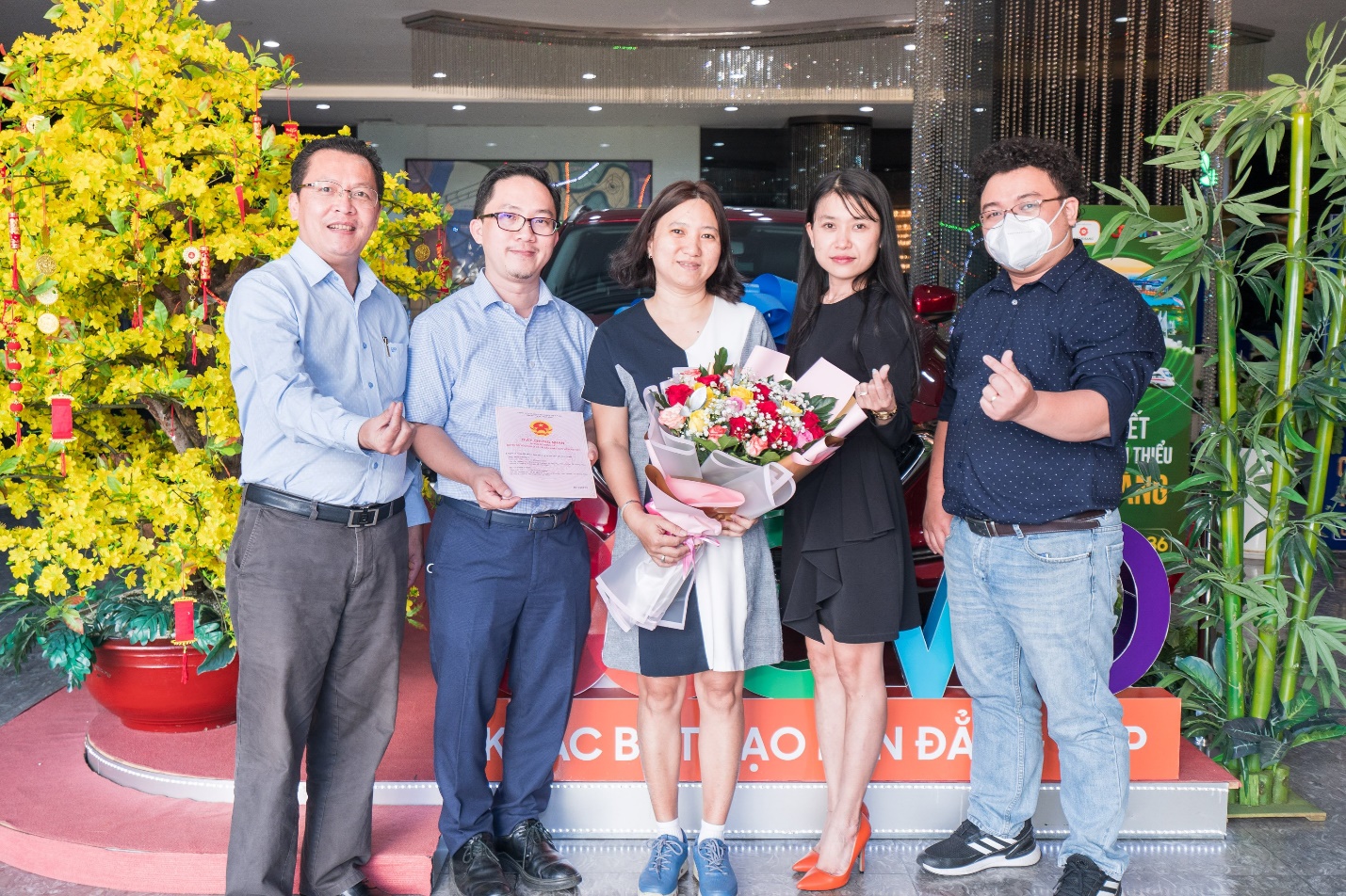 Đại diện đơn vị phân phối dự án Cosmo City bàn giao sổ hồng cho khách hàng.