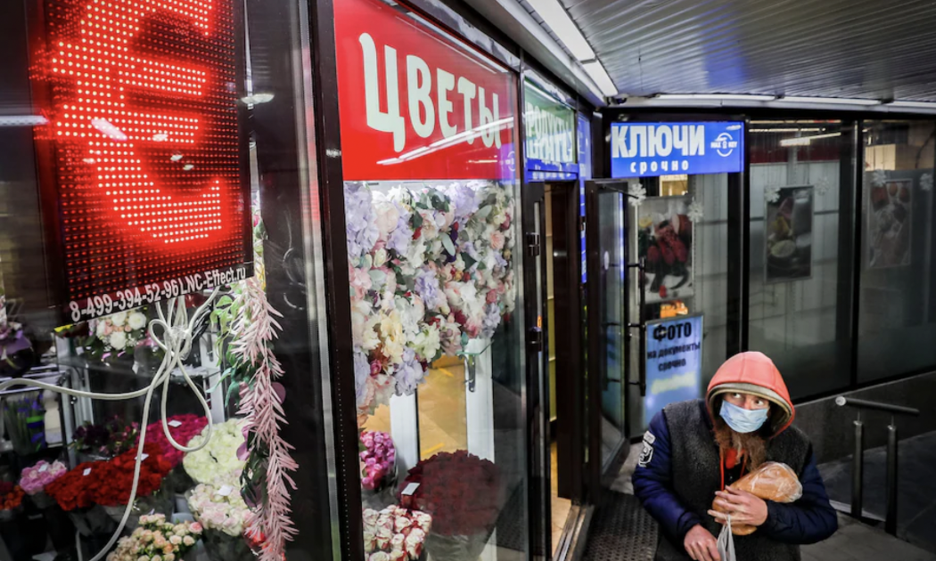 Một người bộ hành đi qua một điểm thu đổi ngoại tệ ở Moscow - Ảnh: EPA/WP.