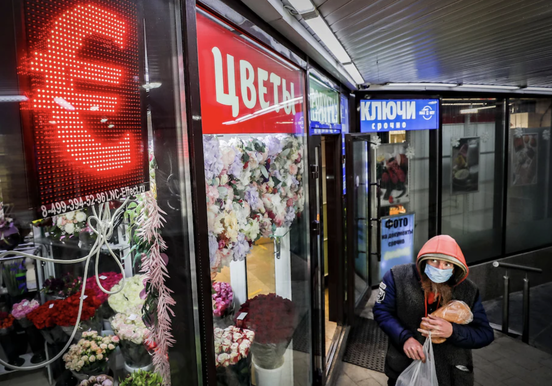 Một người bộ hành đi qua một điểm thu đổi ngoại tệ ở Moscow - Ảnh: EPA/WP.