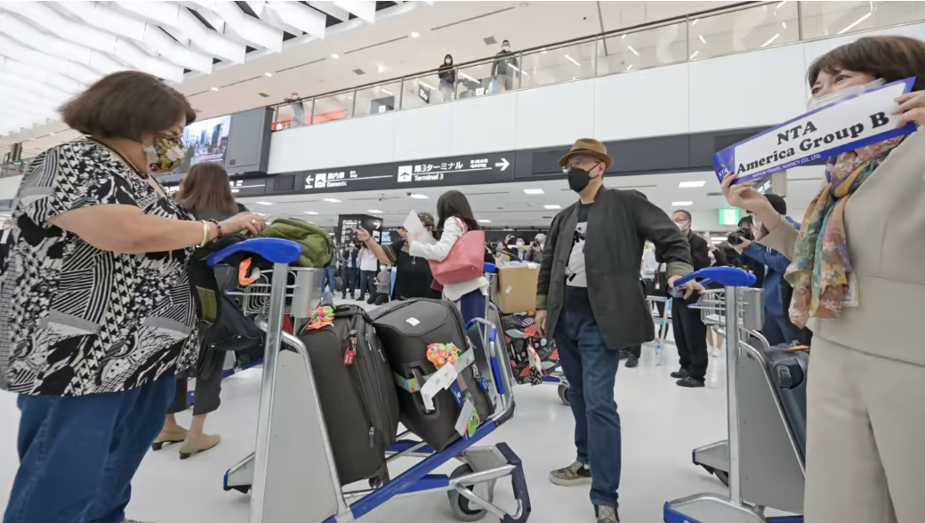 Du khách nước ngoài đến Sân bay Quốc tế Narita tại Tokyo ngày 24/5  tháng 5 theo chương trình thí điểm mở cửa du lịch của Chính phủ Nhật - Ảnh: Nikkei Asia