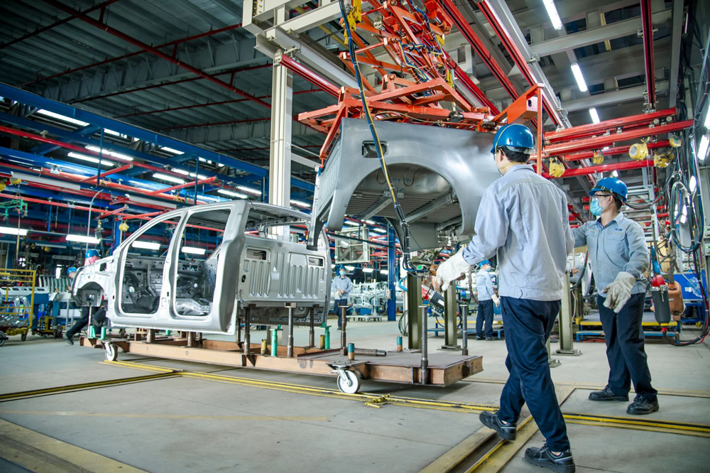 Công nhân nhà máy di chuyển một phần thân xe với sự hỗ trợ của dây chuyền lắp ráp tự động tại nhà máy Ford Hải Dương.