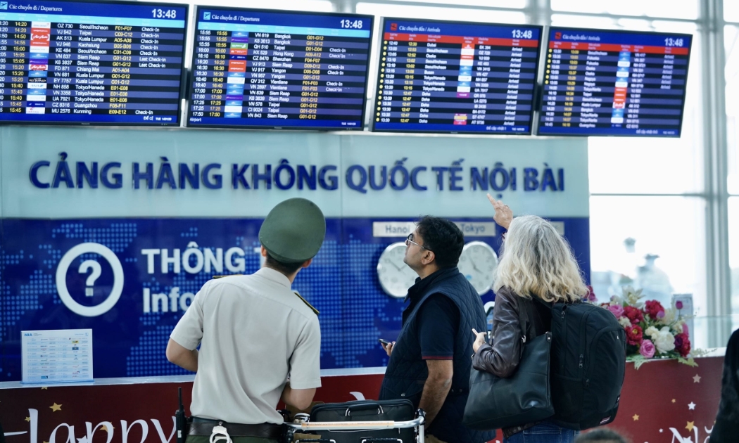 Một nhân viên an ninh hỗ trợ hướng dẫn hành khách tại Cảng hàng không quốc tế Nội Bài.