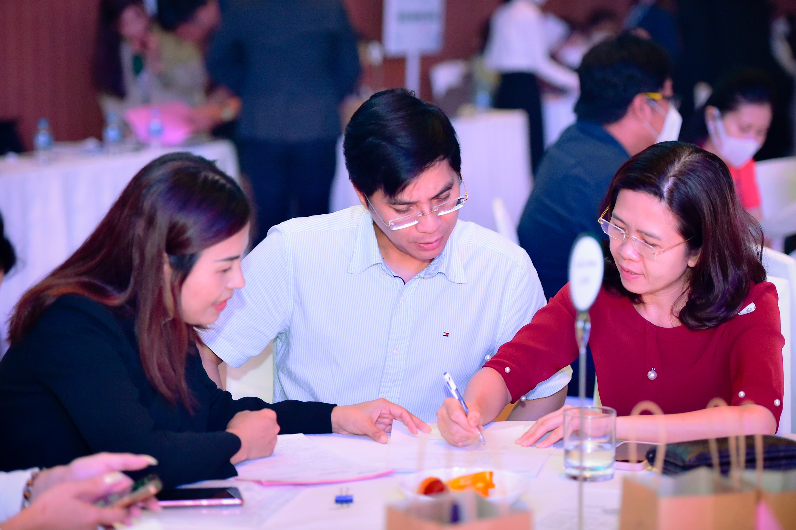 Đội ngũ nh&acirc;n vi&ecirc;n kinh doanh cung cấp th&ocirc;ng tin đến kh&aacute;ch h&agrave;ng tham dự sự kiện.