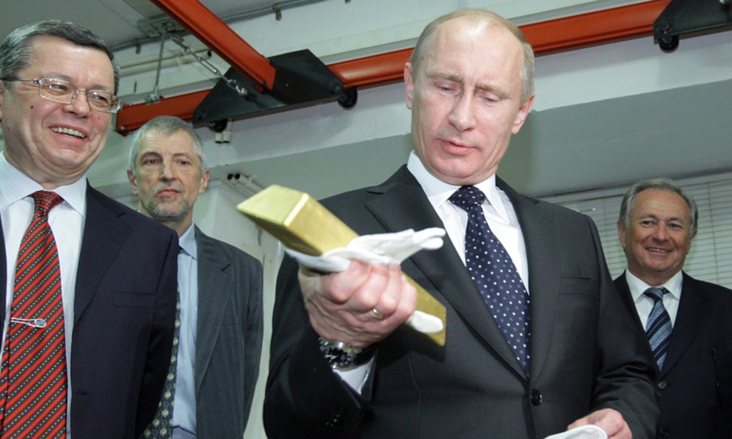 Tổng thống Nga Vladimir Putin cầm một thỏi vàng trong chuyến thăm Kho lưu ký Trung ương của Ngân hàng Trung ương Nga khi ông còn là thủ tướng vào tháng 1/2011 - Ảnh: AFP