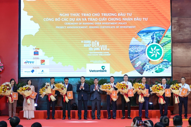 Lãnh đạo tỉnh Hậu Giang trao giấy chứng nhận quyết định chủ trương đầu tư cho các nhà đầu tư. Ảnh - VGP. 