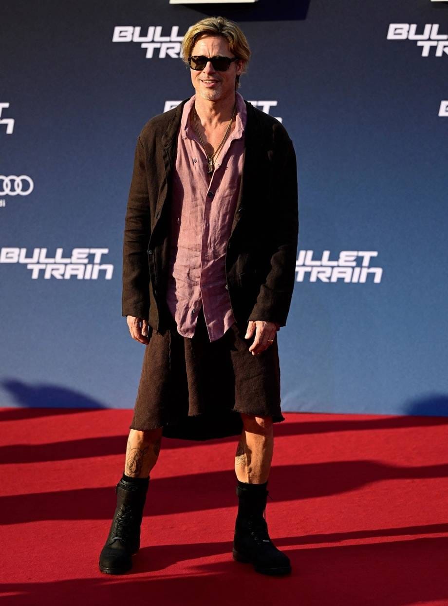 Brad Pitt diện chân váy linen màu nâu đồng điệu áo khoác, sơ mi màu hồng bỏ cúc, lên thảm đỏ quảng bá phim Bullet Train.