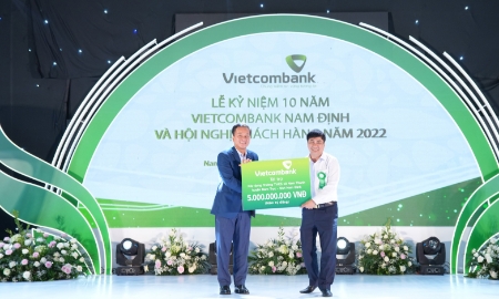 Thay mặt Ban lãnh đạo Vietcombank, ông Nguyễn Việt Cường - Phó Tổng Giám đốc trao biển tượng trưng số tiền ủng hộ của Vietcombank để xây dựng trường Trung học cơ sở xã Nam Thanh, huyện Nam Trực, tỉnh Nam Định.