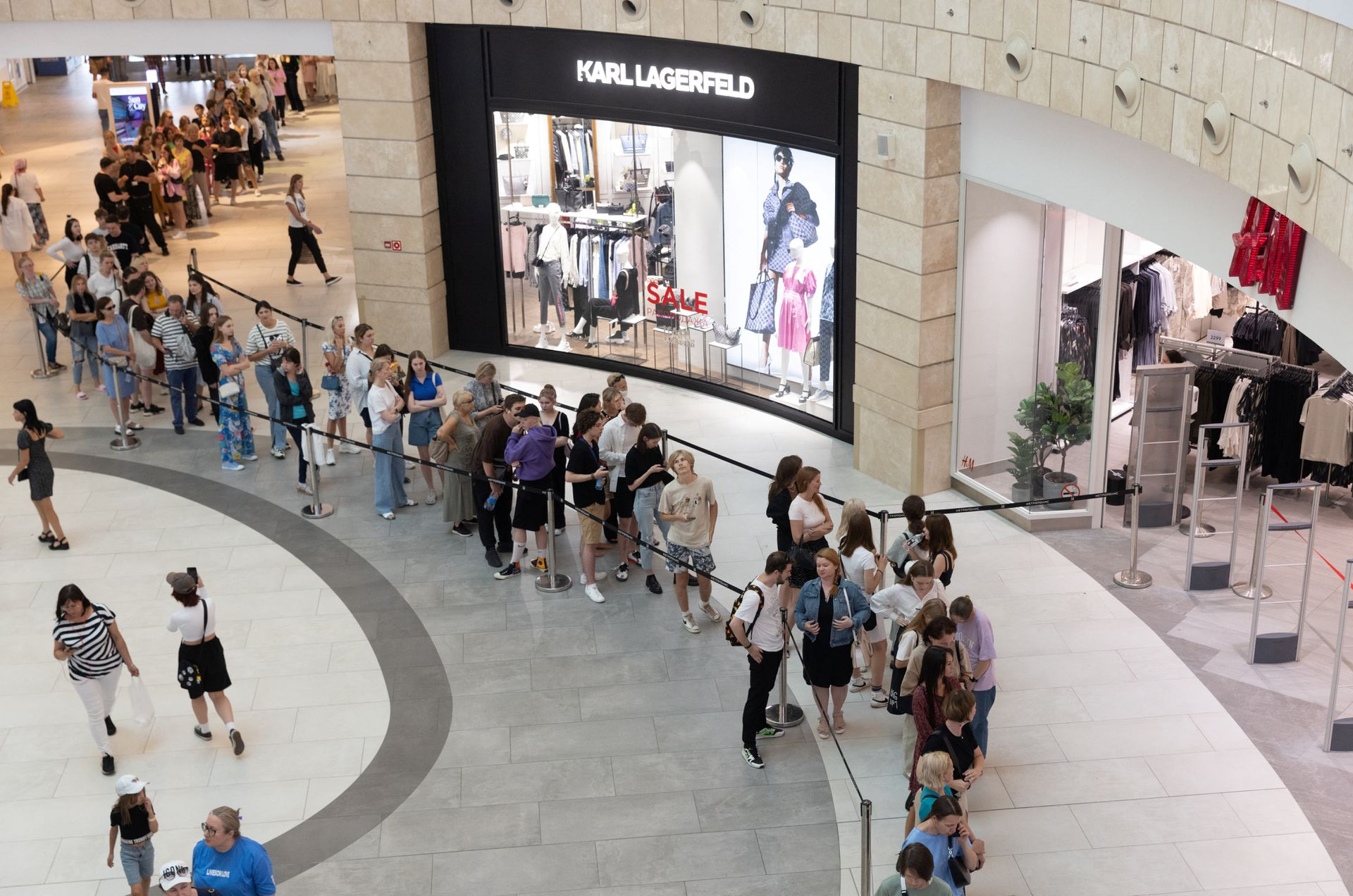 Từng hàng dài người xếp hàng từ cửa hàng H&M bên trong khu trung tâm thương mại ra đến tận ngoài đường để được vào mua sắm.