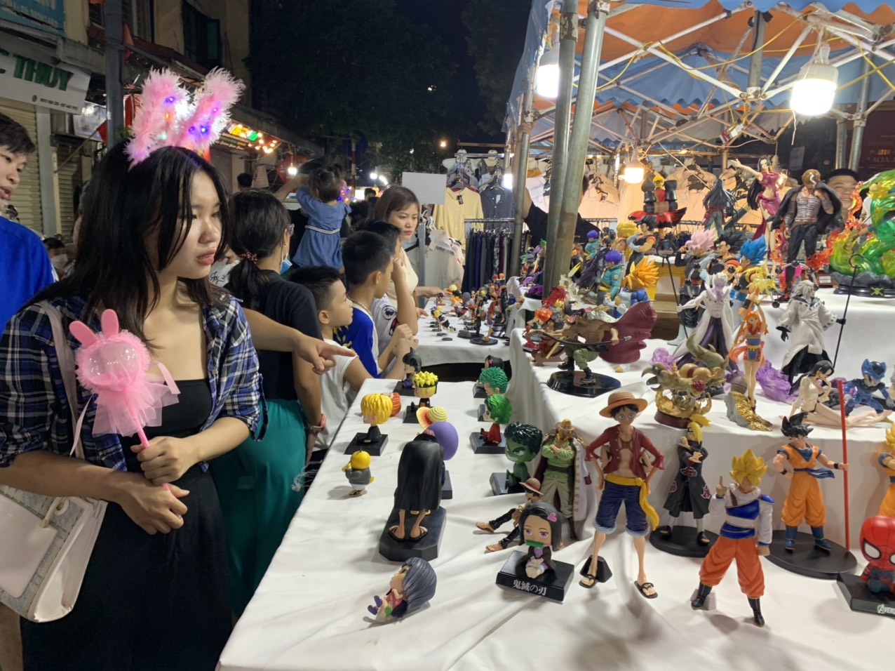 Các gian hàng bán đồ chơi mô hình, vòng, kiếm đồ chơi phát sáng... kiếm bộn tiền từ trẻ nhỏ, thanh thiếu niên.