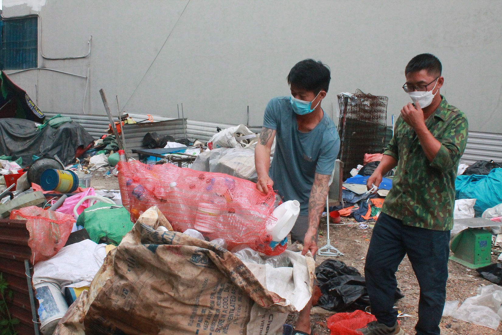 Anh Phạm Văn Đạt (bên trái) phân loại rác thải