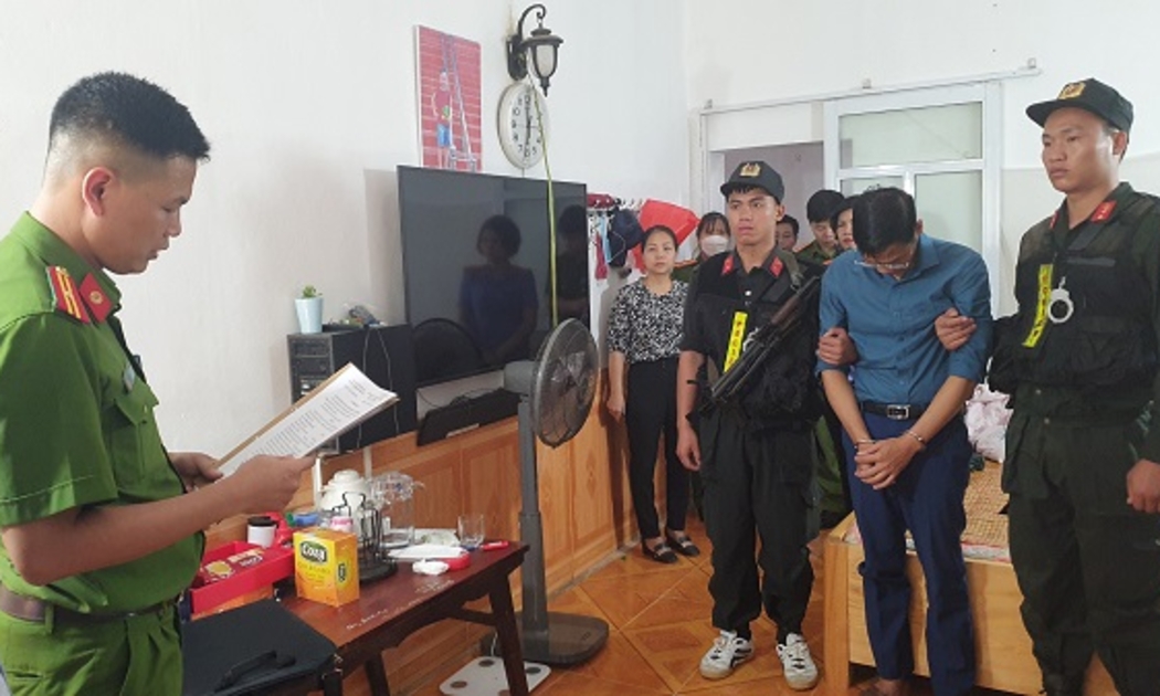 Bị can Phạm Trung Kiên (áo xanh than) nghe đọc lệnh khám xét khẩn cấp tại nhà riêng