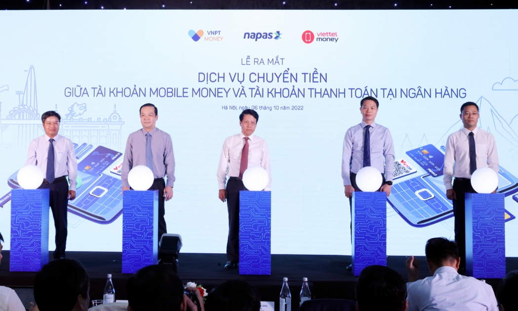Các đại biểu thực hiện nghi thức ấn nút ra mắt dịch vụ chuyển tiền giữa Mobile Money và tài khoản ngân hàng.