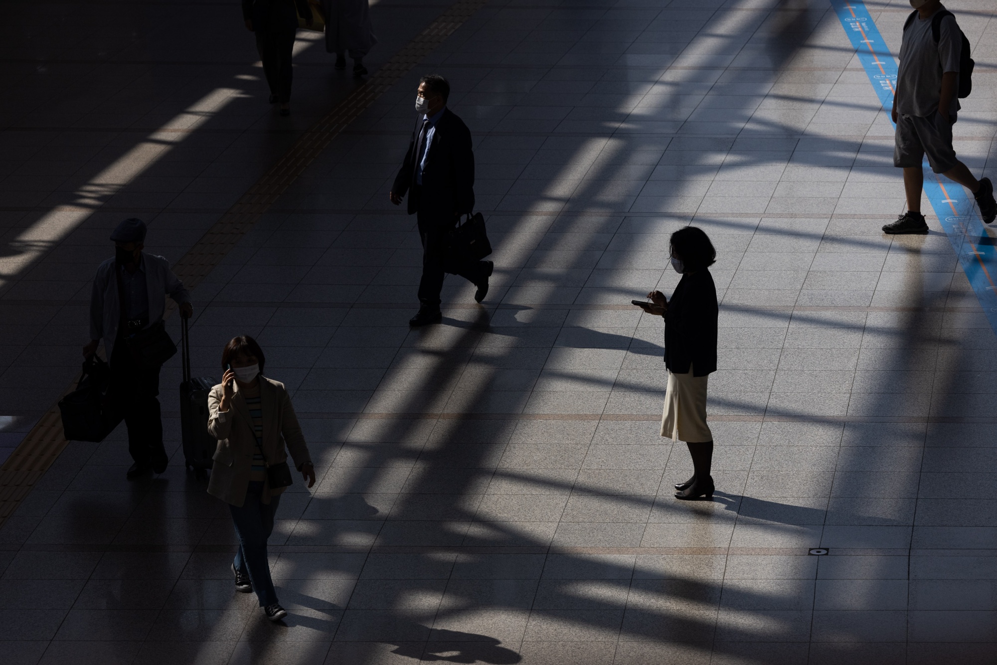 Một người đi bộ sử dụng điện thoại thông minh tại ga Seoul, Hàn Quốc. Ảnh: Bloomberg