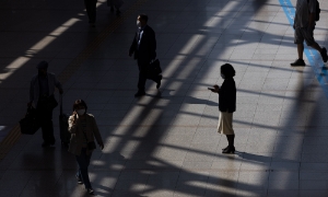 Một người đi bộ sử dụng điện thoại thông minh tại ga Seoul, Hàn Quốc. Ảnh: Bloomberg