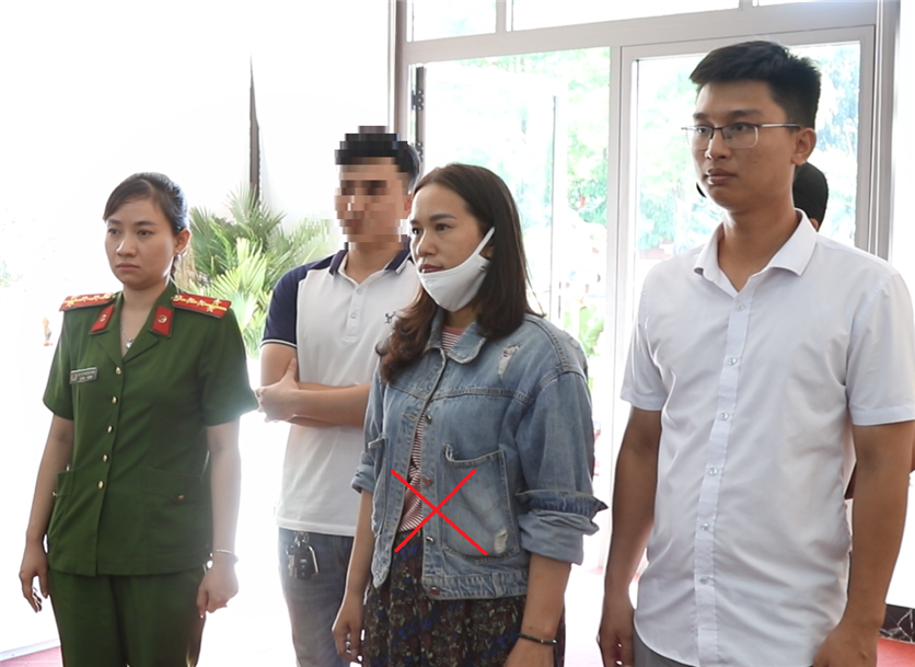Đại úy Đặng Sỹ Thuyết (áo sơ mi trắng) khám xét nơi làm việc của Nguyễn Thị Lệ Nhi (X). (Ảnh: Công an tỉnh Quảng Bình)