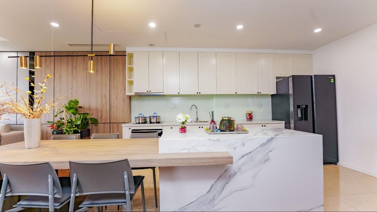 Trong khi đ&oacute;, c&aacute;c thiết bị đến từ Hafele - thương hiệu nội thất cao cấp từ Đức chiếm trọn kh&ocirc;ng gian nh&agrave; bếp: từ bếp nấu đến m&aacute;y h&uacute;t m&ugrave;i, v&ograve;i rửa, chậu rửa&hellip;