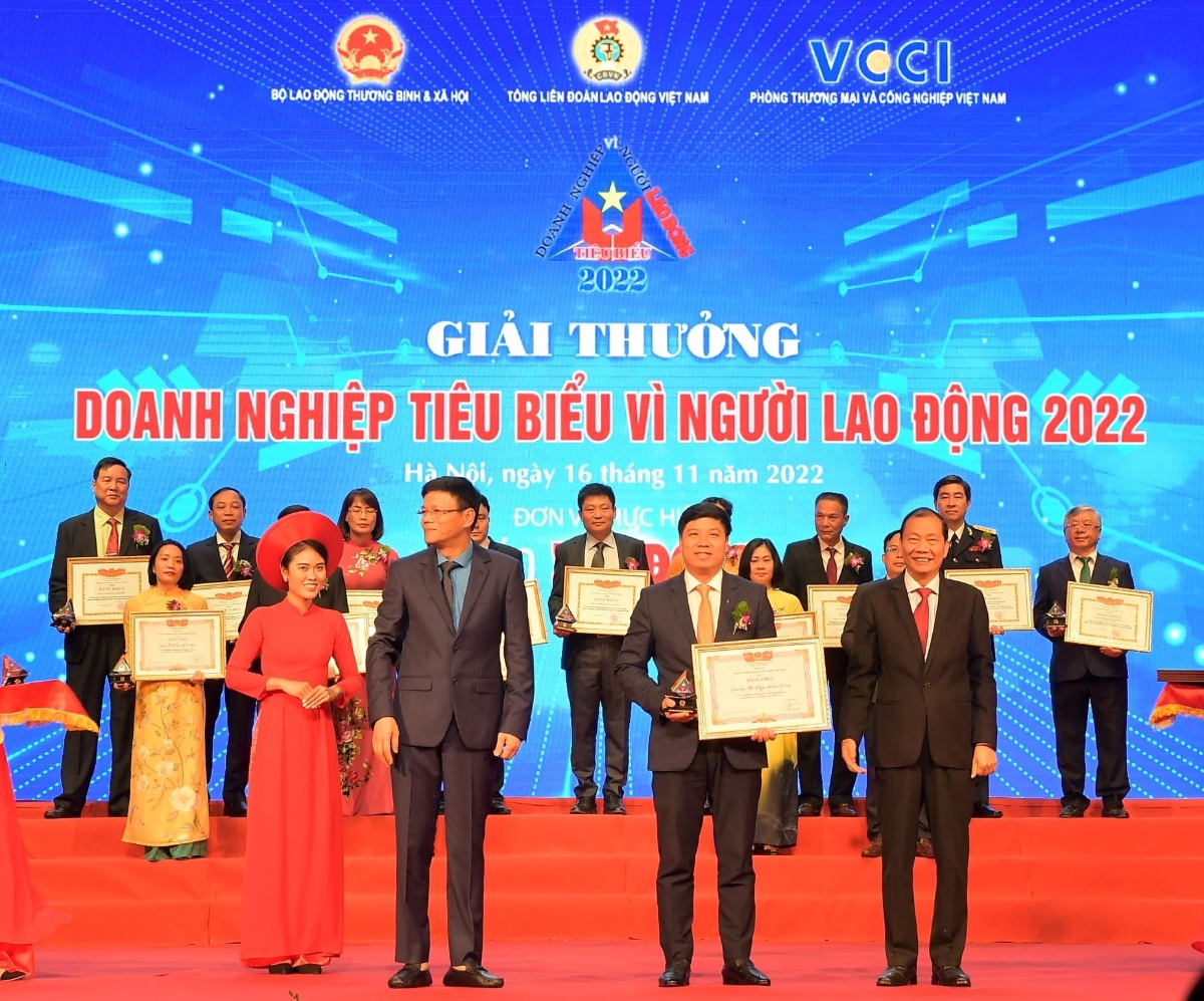 Đồng chí Hoàng Quang Phòng - Phó Chủ tịch VCCI (bên phải) trao Bằng khen “Doanh nghiệp tiêu biểu vì người lao động” của VCCI và đồng chí Nguyễn Ngọc Hiển - Ủy viên Đoàn Chủ tịch Tổng Liên đoàn Lao động Việt Nam, Tổng biên tập báo Lao Động (bên trái) tặng Kỷ niệm chương cho ông Hồng Quang - Thành viên HĐQT kiêm Giám đốc Khối Nhân sự, Chủ tịch Công đoàn Vietcombank - đại diện Vietcombank.