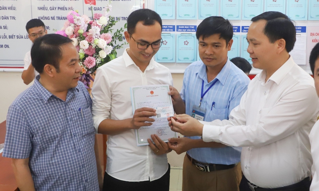 Phó Tổng Giám đốc Bảo hiểm xã hội Việt Nam Chu Mạnh Sinh trao thẻ bảo hiểm y tế của bé Đinh Bảo N cho anh Đinh Văn Hoàng.