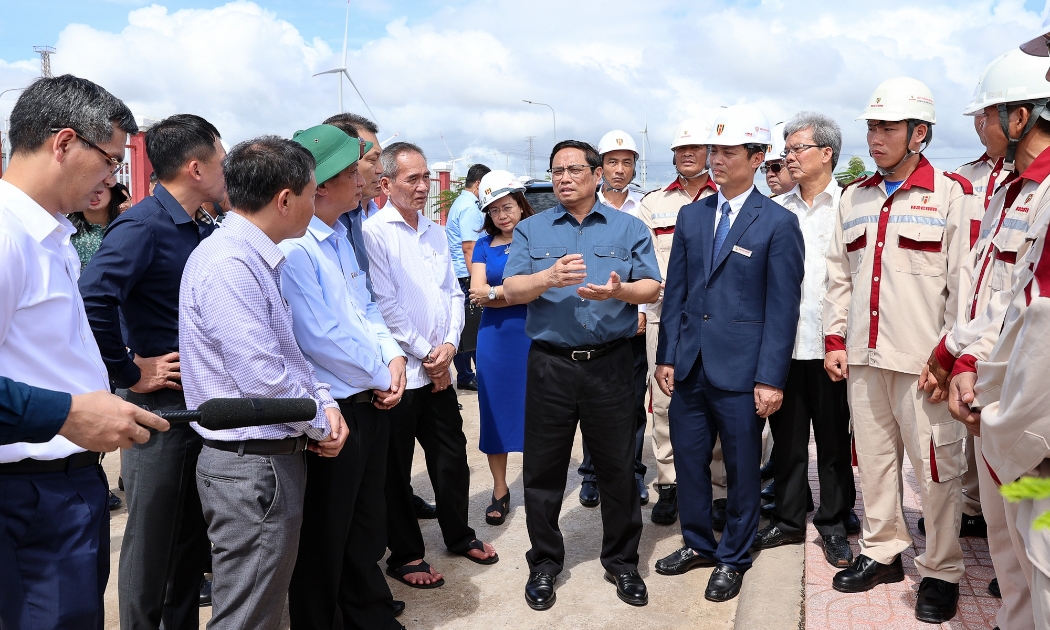 Thủ tướng trao đổi với đội ngũ kỹ sư, chủ đầu tư khi đi khảo sát dự án điện gió Hòa Bình tại xã Vĩnh Thịnh, huyện Hòa Bình, tỉnh Bạc Liêu - Ảnh: VGP