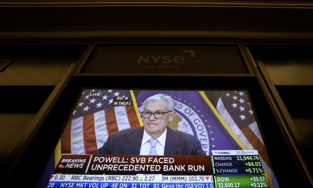 Một màn hình tại Sở giao dịch Chứng khoán New York (NYSE) đưa tin về cuộc họp báo ngày 22/3 của Chủ tịch Fed Jerome Powell - Ảnh: Reuters.