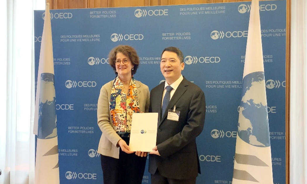 Bà Josée Fecteau, Trưởng Ban Pháp chế OECD trao bản sao chứng thực Hiệp định MAAC cho Thứ trưởng Bộ Tài chính Cao Anh Tuấn.